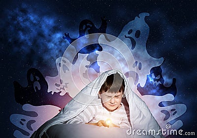 Scared boy hiding under blanket Stock Photo