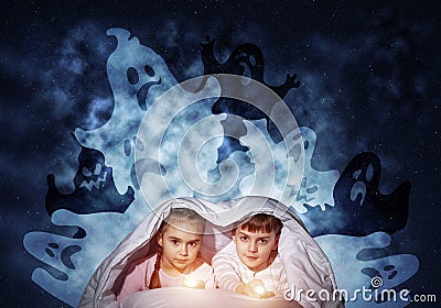 Scared children in pajamas with flashlights Stock Photo