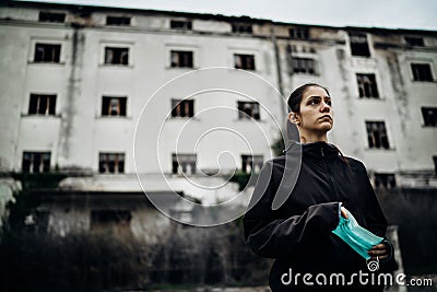 Scared devastated woman holding protective mask.Activities in time of epidemic/pandemic.Panic and fear of infection. Stock Photo