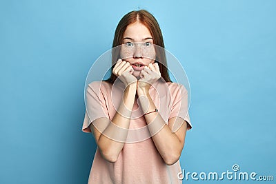 Scared emotional unhappy girl keeps hands under chin Stock Photo