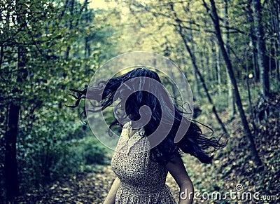 Scared girl running in the forest Stock Photo