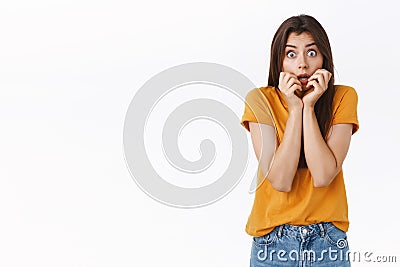 Scared, insecure shocked timid woman in yellow t-shirt, gasping stare camera shook, open mouth, hold hands near lips Stock Photo