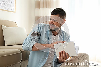 Scared man with tarantula. Arachnophobia fear of spiders Stock Photo