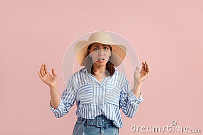 Scared nervous woman with dark hair is afraid of something, keeps mouth open and palms raised, looks at camera, wears Stock Photo