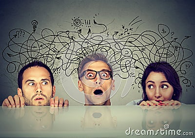 Scared people exchanging share different thought peeking from under the table Stock Photo