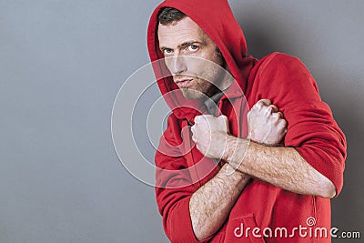 Scared 40s man standing with fists crossed on chest Stock Photo