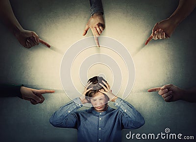 Scared teenager panic under pressure, hands to head, eyes closed feeling discomfort and emotional stress as a lot of hands fingers Stock Photo