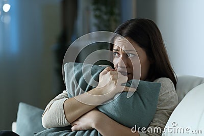 Scared woman embracing pillow at home in the night Stock Photo