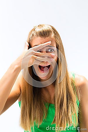 Scared woman peeking from fingers over the face Stock Photo