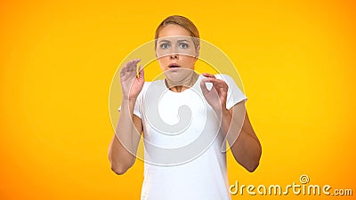Scared young lady bright background, fear of new opportunities, terrified woman Stock Photo