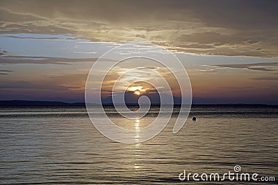 Scarlet red sunset over the sea. September in Greece. Sithonia. The sun and clouds and unusual colors. Glare on the water. Stock Photo