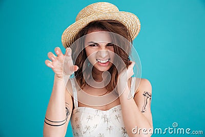 Scary angry woman in straw hat making cat claws gesture Stock Photo