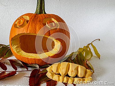 Scary carved pumpkin without teeth, teeth next to pumpkin Stock Photo