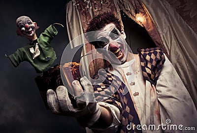 Scary clown holding a Jack-in-the-box toy Stock Photo