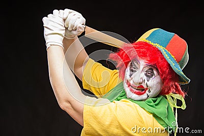 Scary clown joker with a smile and red hair with a big knife on Stock Photo