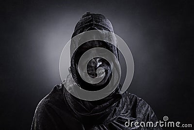 Scary figure with hooded cape in the dark Stock Photo