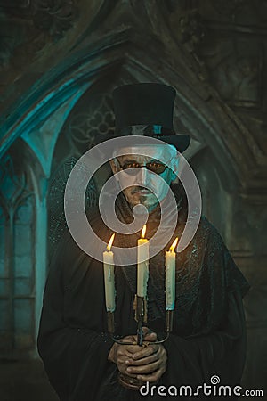 Scary man with candles in the candelabra. Stock Photo