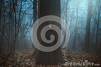 Scary masked man in a misty forest Stock Photo