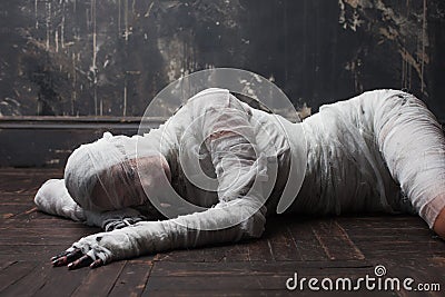 Scary mummy creeps on you. The girl with the bandage on the floor Stock Photo