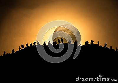 Scary view crowd of zombies on hill with spooky cloudy sky with fog and rising full moon. Silhouette group of zombie walking under Stock Photo