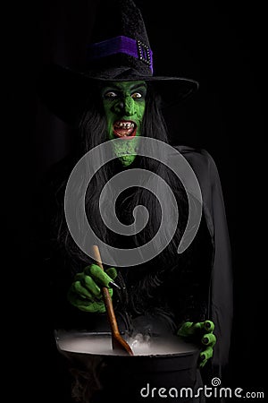 Scary witch stirring her cauldron Stock Photo