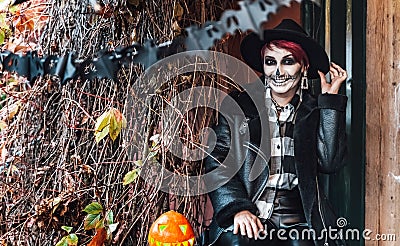 Scary woman,girl celebrating halloween.Terrifying black skull half-face skeleton makeup.Witch costume,stylish image Stock Photo