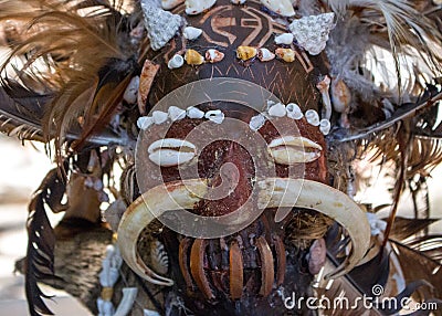 Scary wooden mask of asian totem. Head of ritual sculpture. Carnival decoration. Trible symbol. Ancient religious mask. Stock Photo