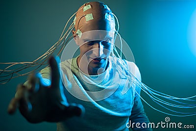 A scary young man with his head entangled in wires, uses mind control Stock Photo