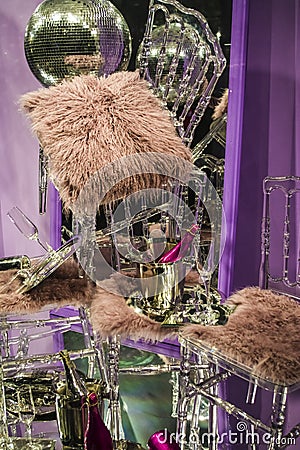 The scattered chairs and glasses, champagne bottles. Exposition. Decorative show-window. Pink colors. Unusual decision. Chaos. Stock Photo