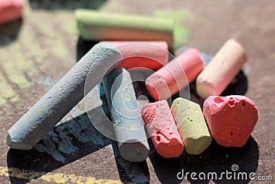 Scattered colorful crayon chalks on black boar Stock Photo