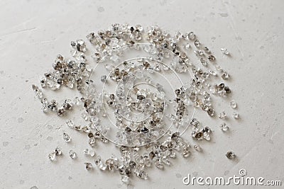 Scattered diamonds on a grey background. Raw diamonds and mining, a scattering of natural diamond stones. Graphite quartz. Natural Stock Photo