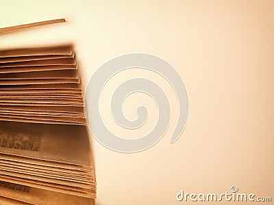 Scattered pages of an open book, on beige Stock Photo