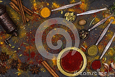 Scattered spices, spice mill, iron spoons and bowls as background Stock Photo