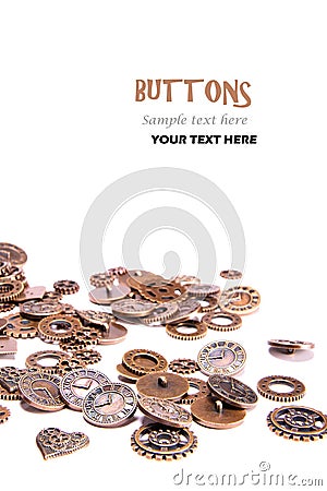 Scattered vintage copper metal buttons on a white background, shaped as gears, hearts, and clock pieces. Steam Punk Stock Photo