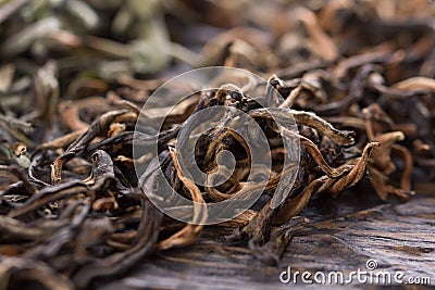 A scattering of black tea on a wooden background, macro Stock Photo