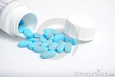 Scattering blue pills from bottle on white background Stock Photo