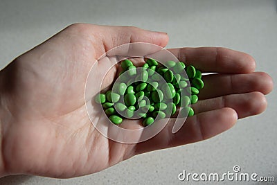 A scattering of green pills in the palm Stock Photo