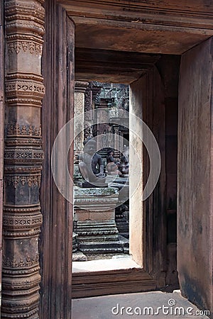 Decorated entrance way to the 10th century Banteay Srei temple with statues in beyond Stock Photo