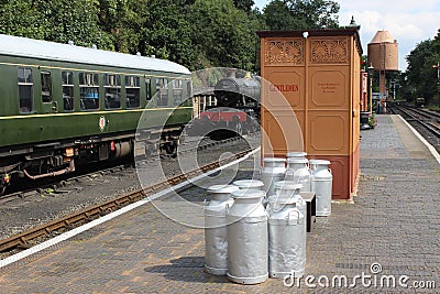 Silver colored milk churns on station platform Editorial Stock Photo