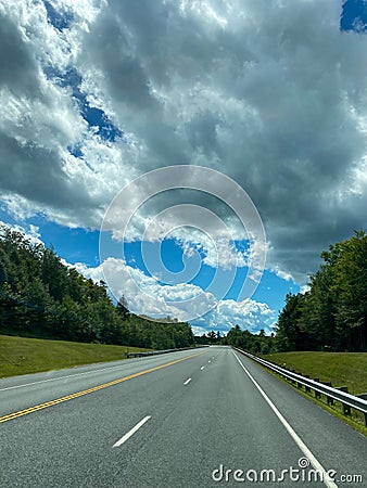 Driving on an deserted highway empty road heading into cloudy storming weather Stock Photo
