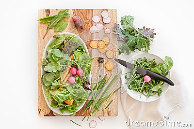 A scene of fresh produce ingredients on a wooden cutting block in a kitchen. Stock Photo