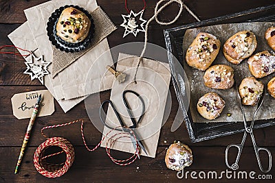 Scene for gifts in Advent with mini stollen, paper bags, and gift ribbon on dark wooden back ground Stock Photo