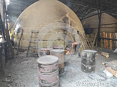 Scene of the worker putting mangrove logs into the charcoal kiln to produce pure carbon Editorial Stock Photo