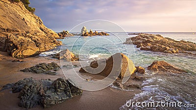 Scenery beach at sunrise. Spanish beach. Rocks and stones on sea shore. Amazing view on sea Stock Photo
