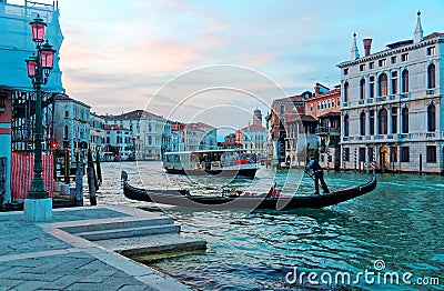 Scenery of romantic Venice at sunset, with view of a gondolier steering his ferry gondola by a pier, a vaporetto waterbus Editorial Stock Photo