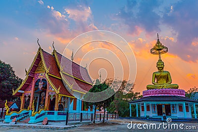 Scenery sunset behind the golden buddha in Chiang Rai Stock Photo