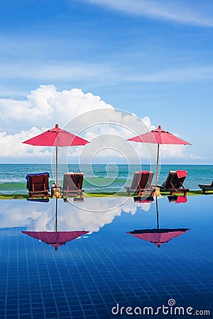 Scenery tropical resort with swimming pool near palm beach on sunny day Stock Photo