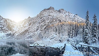 Scenery winter mountains. Amazing snowy rocks and icy lake. Beautiful view on High mountain covered by snow. Frosty nature Stock Photo