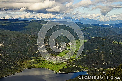 Scenic aerial panoramic view of Bohinj Lake with mountain range and valley with small village Stock Photo