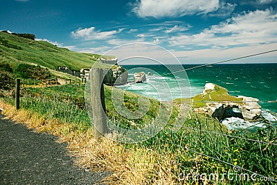 A scenic coastal path overlooking turquoise waters and rugged cliffs Stock Photo